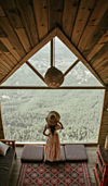 femme dans un chalet au bord de la fenetre